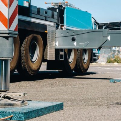 Ciężarówka z wysuniętymi podporami używa podkładów stabilizujących pod stopy HDS.